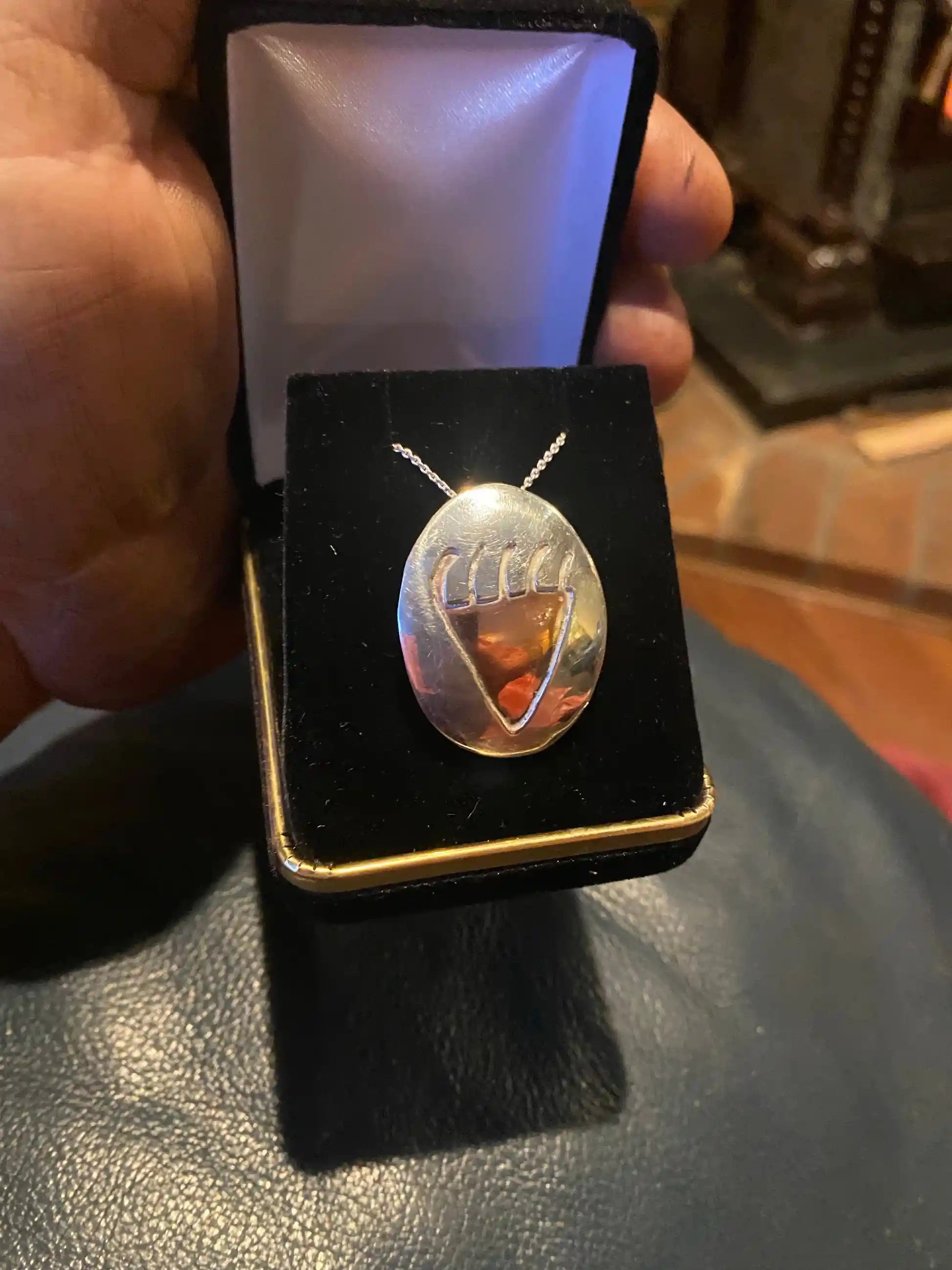 Man Hand_holding_Bear_Paw_Pictograph_Necklace